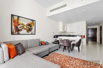 a living room with a couch and a table at WelHome - Charming Breathtaking 1BR Apt. In Damac Hills in Dubai