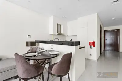 a kitchen with a table and chairs in a room at WelHome - Charming Breathtaking 1BR Apt. In Damac Hills in Dubai