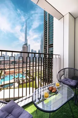 a balcony with a table and chairs and a view of a city at FULL Burj Khalifa view 2BR with Dubai Mall connection in Downtown in Dubai