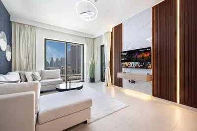 a living room with a couch and a tv at FULL Burj Khalifa view 2BR with Dubai Mall connection in Downtown in Dubai
