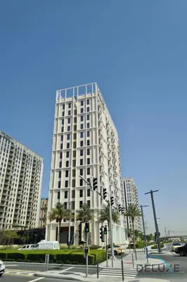 a tall white building with palm trees in front of it at Enchanting 1BR Apartment in Socio Tower, Dubai Hills Estate by Deluxe Holiday Homes in Dubai