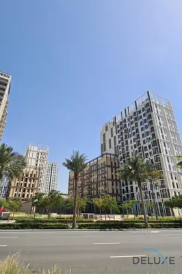 an empty street in front of tall buildings with palm trees at Enchanting 1BR Apartment in Socio Tower, Dubai Hills Estate by Deluxe Holiday Homes in Dubai