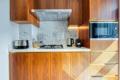 a kitchen with wooden cabinets and a stove top oven at RH - Spacious chic apartment, Next to Dubai Mall in Dubai