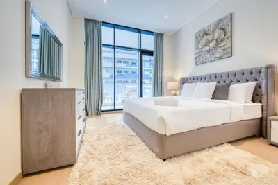 a bedroom with a large bed and a large window at RH - Spacious chic apartment, Next to Dubai Mall in Dubai