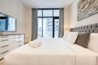 a bedroom with two white beds and a large window at RH - Spacious chic apartment, Next to Dubai Mall in Dubai