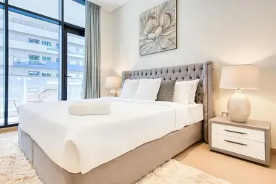 a bedroom with a large bed and a large window at RH - Spacious chic apartment, Next to Dubai Mall in Dubai
