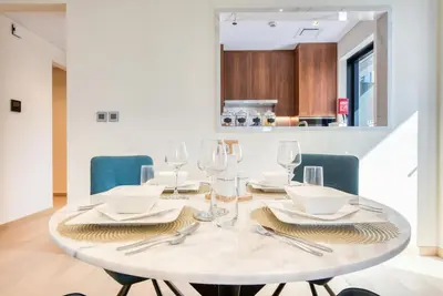 a white dining table with glasses and napkins at RH - Spacious chic apartment, Next to Dubai Mall in Dubai