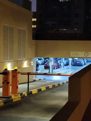 a parking lot with a barrier in a parking garage at quiet green 1 bedroom for your rest in Dubai