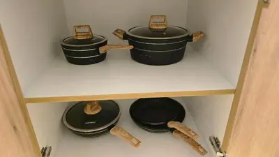 four pots and pans sitting on a shelf at quiet green 1 bedroom for your rest in Dubai