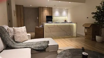 a living room with a couch and a kitchen at quiet green 1 bedroom for your rest in Dubai