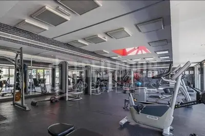 a gym with treadmills and machines in a building at quiet green 1 bedroom for your rest in Dubai