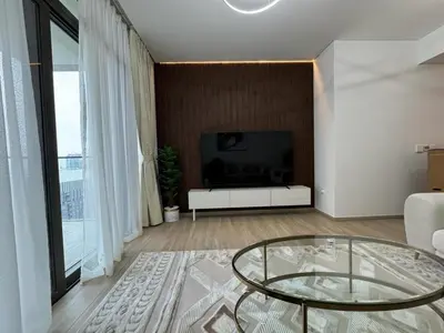 a living room with a glass table and a television at High Floor, 1 Bedroom in Palace Residence in Dubai