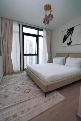 a bedroom with a large bed and a large window at High Floor, 1 Bedroom in Palace Residence in Dubai