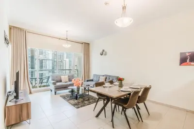 a living room with a table and chairs and a tv at RH - Best location, 01 BR Spacious, walk to burj in Dubai