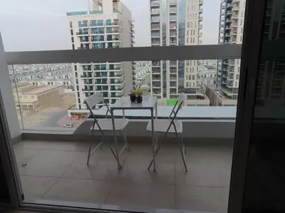 a table and chairs in a balcony with a view of a city at Dubai 7 in Dubai