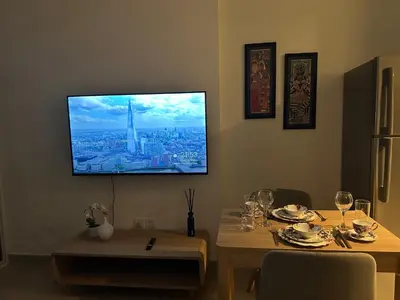 a dining room with a table with a television on the wall at Dubai 7 in Dubai
