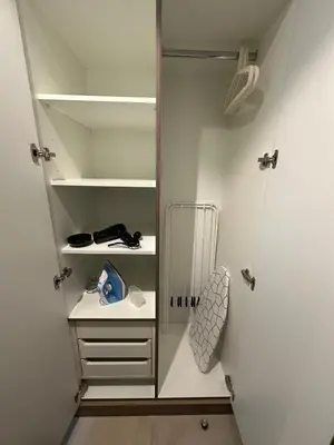 a walk in closet with white cabinets and shelves at Dubai 7 in Dubai