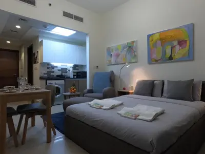 a bedroom with a bed and a table and a kitchen at Dubai 7 in Dubai