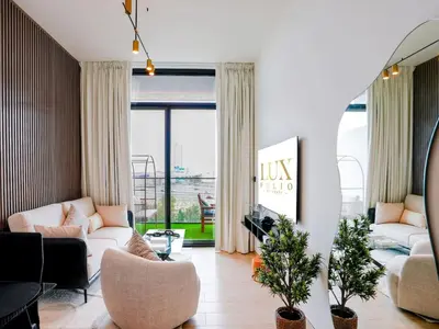 a living room with a couch and a table at Stylish JVC 1 Bedroom Sanctuary in Dubai