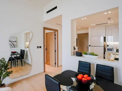 a living room with a table and a dining room at Stylish JVC 1 Bedroom Sanctuary in Dubai