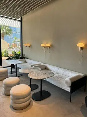 a living room with a white couch and two tables at Houzzze #4 DesignStudio Burj Khalifa view in Dubai