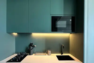 a kitchen with blue cabinets and a sink and a microwave at Houzzze #4 DesignStudio Burj Khalifa view in Dubai