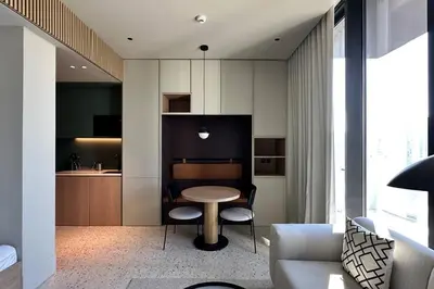 a living room with a table and a kitchen at Houzzze #4 DesignStudio Burj Khalifa view in Dubai