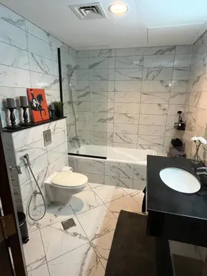 a bathroom with a toilet and a sink and a tub at Specious cosy bedroom in Al Sufouh in Dubai