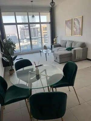a living room with a glass table and green chairs at Specious cosy bedroom in Al Sufouh in Dubai