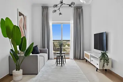 a living room with a couch and a tv at Silkhaus High Floor 1 BDR with Metro Nearby in Dubai