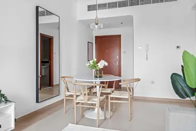 a dining room with a table and chairs and a mirror at Silkhaus High Floor 1 BDR with Metro Nearby in Dubai