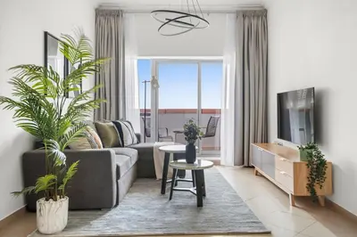 a living room with a couch and a tv at Silkhaus Metro Close To Barsha Heights in Dubai