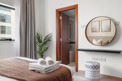 a bedroom with a bed with towels and a mirror at Silkhaus Metro Close To Barsha Heights in Dubai