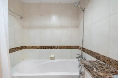 a bathroom with a tub and a sink at Silkhaus Metro Close To Barsha Heights in Dubai