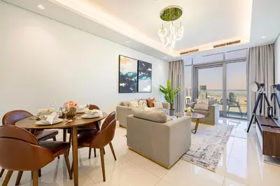 a living room with a table and a dining room at 2BR High Floor Infinity Pool w/ Burj Khalifa view in Dubai