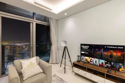 a living room with a large flat screen tv at 2BR High Floor Infinity Pool w/ Burj Khalifa view in Dubai