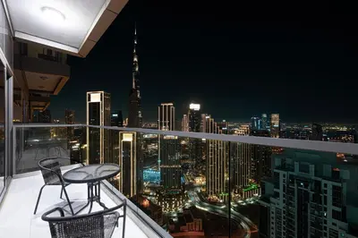 a view of a city skyline at night from a balcony at 2BR High Floor Infinity Pool w/ Burj Khalifa view in Dubai