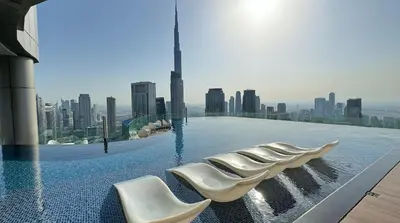 a swimming pool on top of a building with a city skyline at 2BR High Floor Infinity Pool w/ Burj Khalifa view in Dubai
