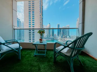 a balcony with two chairs and a table with a view at Dubai Marina Delight: Spacious Retreat for Groups in Dubai