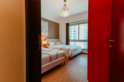 a hotel room with two beds and a window at Dubai Marina Delight: Spacious Retreat for Groups in Dubai