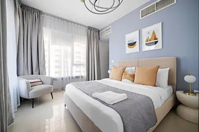 a bedroom with a large bed and a chair at Silkhaus Modern 1 BDR With Easy Access to Downtown in Dubai