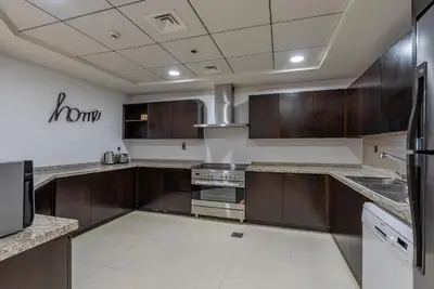 a large kitchen with wooden cabinets and stainless steel appliances at Balqis Residences I Spacious and Modern 4BDR I Palm Jumeirah in Dubai