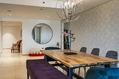 a dining room with a wooden table and blue chairs at Balqis Residences I Spacious and Modern 4BDR I Palm Jumeirah in Dubai