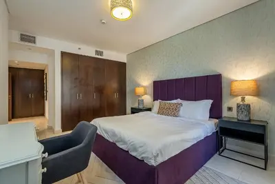a bedroom with a large bed with a purple headboard at Balqis Residences I Spacious and Modern 4BDR I Palm Jumeirah in Dubai