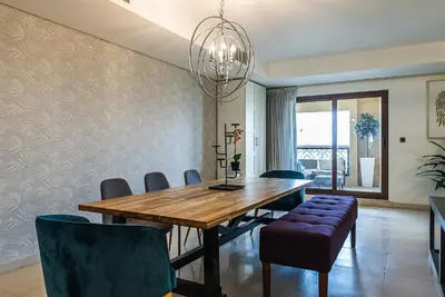 a dining room with a wooden table and chairs at Balqis Residences I Spacious and Modern 4BDR I Palm Jumeirah in Dubai