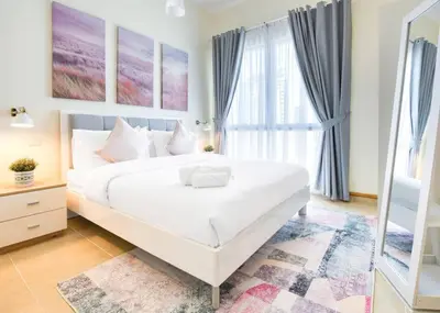 a bedroom with a large white bed and a window at Exclusive 2BR Apartment in Madison Residency - Close to Dubai Internet City Metro Station in Dubai