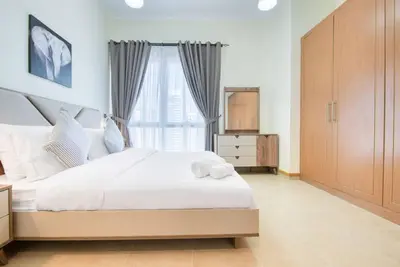 a bedroom with a white bed and a window at Exclusive 2BR Apartment in Madison Residency - Close to Dubai Internet City Metro Station in Dubai