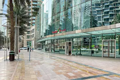 a city street with a large glass building at Luxury 1BR Skyline & Sea Views Walk to Dubai Mall & Burj Khalifa in Dubai