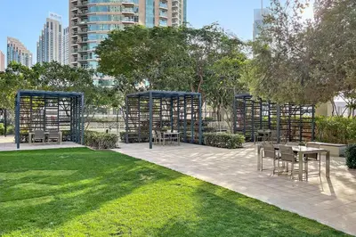 a park with a table and chairs in a park at Luxury 1BR Skyline & Sea Views Walk to Dubai Mall & Burj Khalifa in Dubai