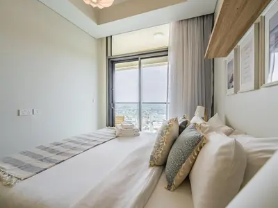 a bedroom with a large bed with a large window at Modern and Cozy Condo With Unobstructed City Views in Dubai
